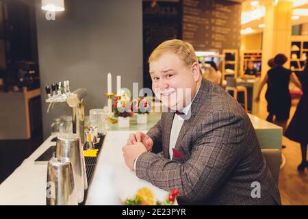 Kerl verbringen Freizeit in der Bar, defokussed Hintergrund. Ein Mann mit strengem Gesicht sitzt in der Bar oder im Pub in der Nähe der Theke. Hipster mit Bart bestellte Getränke, wartet auf Stockfoto