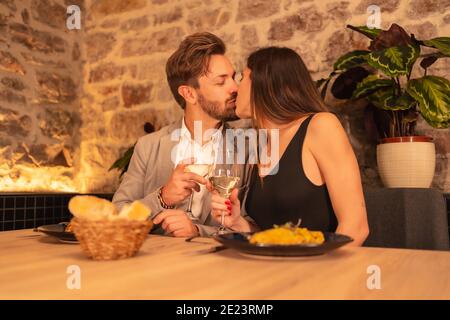 Liebevolles Paar küssen und genießen Abendessen in einem Restaurant Stockfoto