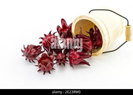 Hibiscus sabdariffa oder roselle Früchte in Holzkiste auf weißem Hintergrund. Stockfoto