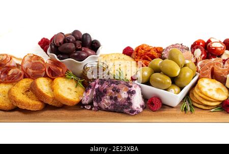 Bohnenkraut Wurstwaren Board in Fleisch Oliven Paprika Beeren und bedeckt Käse Stockfoto