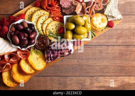 Bohnenkraut Wurstwaren Board in Fleisch Oliven Paprika Beeren und bedeckt Käse Stockfoto