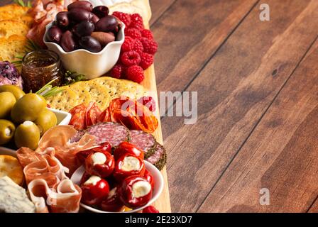 Bohnenkraut Wurstwaren Board in Fleisch Oliven Paprika Beeren und bedeckt Käse Stockfoto