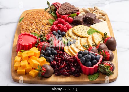 Schokolade überzogene Erdbeeren und Käse Süße Wurstplatte auf einem Theke Aus Marmor Stockfoto