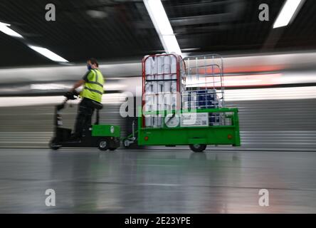 08. Januar 2021, Hessen, Frankfurt/Main: Ein Arbeiter transportiert Papierrollen im Terminal 1 am Frankfurter Flughafen. Die Corona-Krise ist besonders am größten Drehkreuz Deutschlands spürbar. Mit nur gut 400 Flugbewegungen und rund 22,000 Passagieren pro Tag hat der Flughafen ein sehr niedriges Niveau erreicht. (To dpa 'Weltflughafen im Winterschlaf - Mitarbeiter fürchten um Arbeitsplätze') Foto: Arne Dedert/dpa Stockfoto