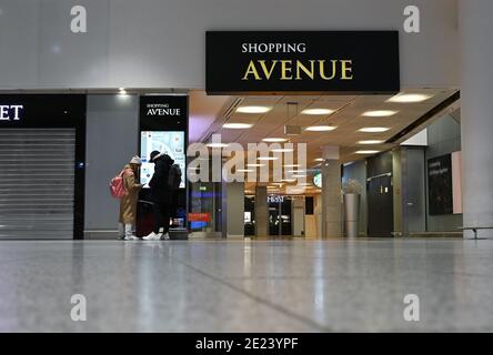 08. Januar 2021, Hessen, Frankfurt/Main: Flugreisende stehen an den geschlossenen Shops im Terminal 1 des Frankfurter Flughafens. Die Corona-Krise zeigt sich besonders an Deutschlands größtem Drehkreuz. Mit nur gut 400 Flugbewegungen und rund 22,000 Passagieren pro Tag hat der Flughafen ein sehr niedriges Niveau erreicht. (To dpa 'Weltflughafen im Winterschlaf - Mitarbeiter fürchten um Arbeitsplätze') Foto: Arne Dedert/dpa Stockfoto