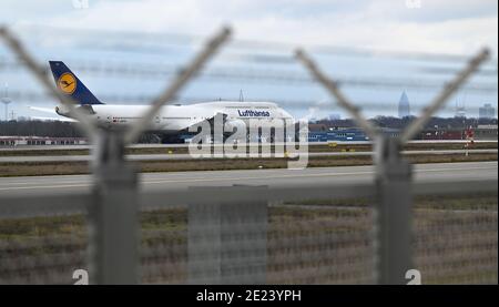 08. Januar 2021, Hessen, Frankfurt/Main: Auf der geschlossenen Nordwest-Start- und Landebahn am Frankfurter Flughafen steht eine Lufthansa Boeing 747-8. Die Corona-Krise zeigt sich besonders an Deutschlands größtem Drehkreuz. Mit nur gut 400 Flugbewegungen und rund 22,000 Passagieren pro Tag hat der Flughafen ein sehr niedriges Niveau erreicht. (To dpa 'Weltflughafen im Winterschlaf - Mitarbeiter fürchten um Arbeitsplätze') Foto: Arne Dedert/dpa Stockfoto