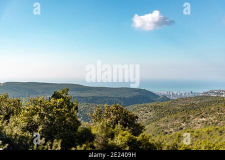 Blick auf Wald, Meer und Stadt unter blauem Himmel. Ein Blick auf den Berg Carmel, die kleine Schweiz, mit Blick auf die Stadt Haifa von oben. Israel. Hochwertige Fotos Stockfoto