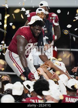 Miami, Usa. Januar 2021. Alabama Crimson Tide Offensivlineman Alex Leatherwood (70) teilt ein Stück der Trophäe mit Teamkollegen nach einem 52-24 Sieg über die Ohio State Buckeyes in der 2021 NCAA National Championship Fußballspiel im Hard Rock Stadium in Miami am Montag, 11. Januar 2021. Der Sieg lieferte Cheftrainer Nick Saban die siebte nationale Meisterschaft ab. Foto von Hans Deryk/UPI Credit: UPI/Alamy Live News Stockfoto