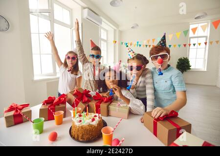Dunkelhäutig Mädchen feiert ihren Geburtstag mit Freunden sitzen an einem Tisch, wo Geschenke und ein Kuchen. Stockfoto