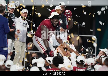 Miami, Usa. Januar 2021. Alabama Crimson Tide Offensivlineman Alex Leatherwood (C) teilt ein Stück der Trophäe mit Teamkollegen nach einem 52-24 Sieg über die Ohio State Buckeyes in der 2021 NCAA National Championship Football Spiel im Hard Rock Stadium in Miami am Montag, 11. Januar 2021. Der Sieg lieferte eine siebte nationale Meisterschaft an Cheftrainer Nick Saban (L). Foto von Hans Deryk/UPI Credit: UPI/Alamy Live News Stockfoto