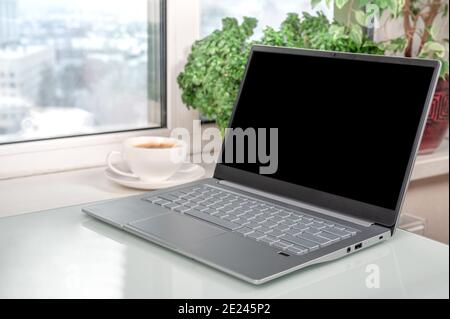 Mockup Laptop. Laptop zeigt leeren Bildschirm im Café oder Home Office. Notebook mit leerem Bildschirm auf dem Tisch im Home Office Space. Arbeitsplatz Heim Roo Stockfoto