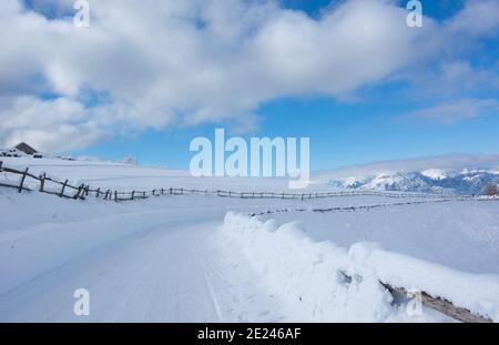 Eine Bergstraße, die nach dem Schneesturm von Neuschnee bedeckt ist. Stockfoto