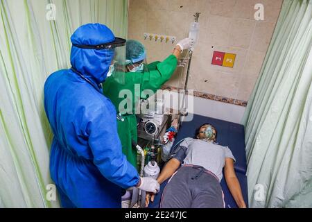Denpasar, Indonesien. Januar 2021. Ein Gesundheitspersonal, das einen Schutzanzug trug, sah, wie eine Frau vor der Impfung gesichtet wurde.das Public Health Centre (Puskesmas) IV von South Denpasar hielt vor dem nationalen Tag der gleichzeitigen Impfung, der vom 14. Dezember 2020 beginnen wird, die Impfungssimulation Covid-19. Kredit: Dicky Bisinglasi/SOPA Images/ZUMA Wire/Alamy Live Nachrichten Stockfoto