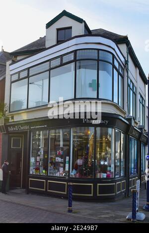 Dieses malerische alte Eckgebäude wird von Pearn's Apotheken besetzt, die in John Street Porthcawl als Balkwill-Apotheke gehandelt werden. Stockfoto