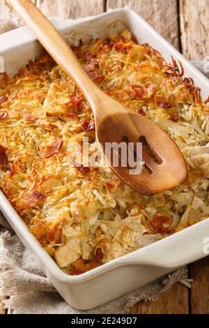 Rappie Pie ist so etwas wie ein gebackener Eintopf von Kartoffeln und Fleisch close-up in einer Backform auf dem Tisch. Vertikal Stockfoto