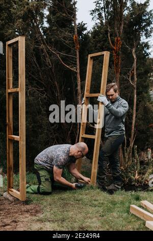 Männer setzen Holzrahmen auf Stockfoto