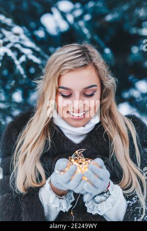 Weihnachten Portrait von schönen jungen Mädchen im Winter Wald mit Beleuchtung Stockfoto