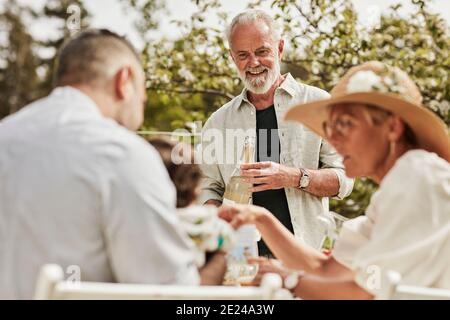 Menschen reden während des Essens im Garten Stockfoto