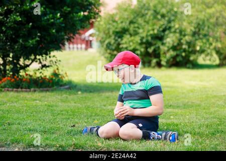 Glücklicher Junge im Garten sitzen Stockfoto