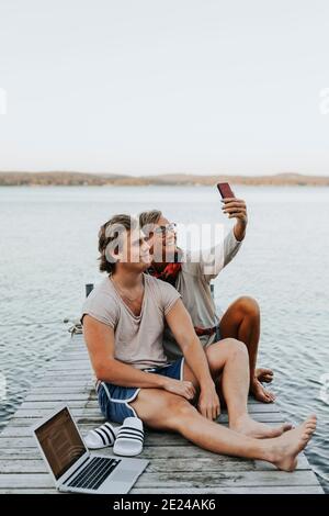 Mutter mit erwachsenem Sohn auf dem Steg, der Selfie nimmt Stockfoto