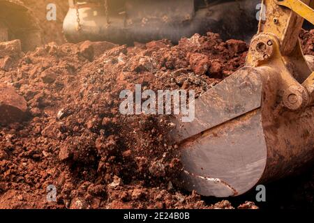 Nahaufnahme Eimer Bagger graben den Boden auf der Baustelle. Raupenbagger graben auf Abbruchstelle. Baggermaschine. Erde bewegt sich Stockfoto