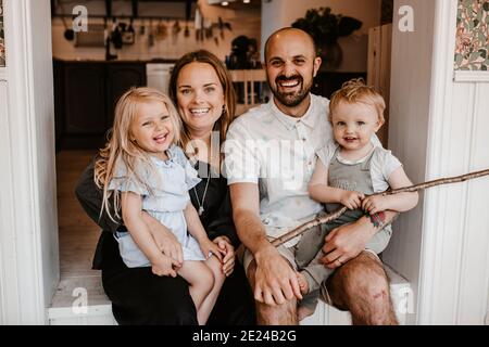 Lächelnde Eltern mit Kindern, die die Kamera betrachten Stockfoto