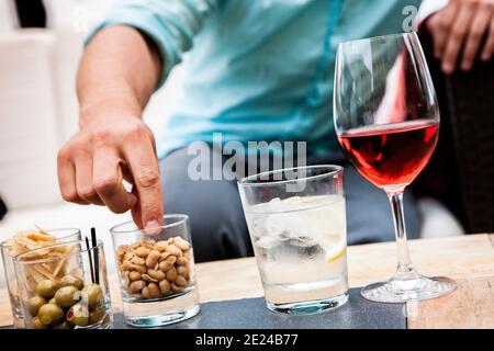 Mans Hand greift nach Smacks auf dem Tisch Stockfoto