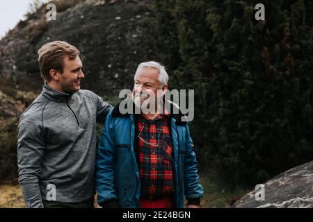 Vater mit erwachsenem Sohn, der sich ansieht Stockfoto