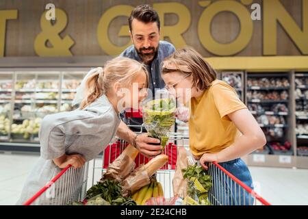 Vater mit Töchtern beim Einkaufen im Supermarkt Stockfoto