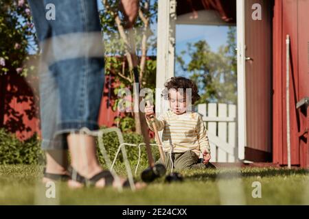 Mutter mit Kleinkind spielt Krocket im Garten Stockfoto