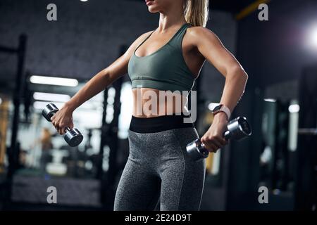 Handgewichte, die von einer Sportlerin seitlich angehoben werden Stockfoto