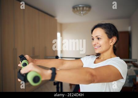 Schöne fröhliche Sportlerin trainieren mit Handgewichten Stockfoto