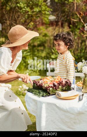 Großmutter mit Enkel im Garten Stockfoto