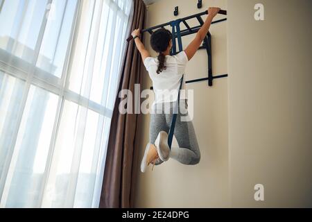 Fit dunkelhaarige junge Frau, die eine Widerstandsübung Stockfoto