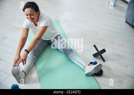 Fröhliche weibliche Yogi, die eine Dehnungsübung durchführen Stockfoto