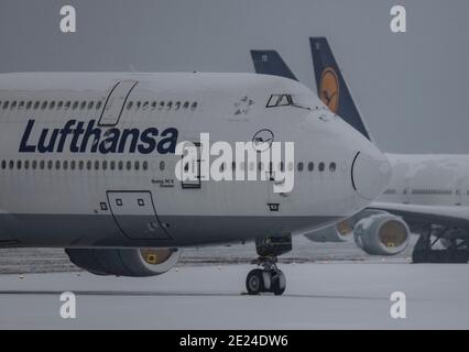 12. Januar 2021, Hessen, Frankfurt/Main: Schnee liegt auf den gestürzte Lufthansa-Passagierflugzeugen, die auf der stillgestellten Nordwest-Landebahn am Frankfurter Flughafen abgestellt sind. Aufgrund der weltweiten Corona-Pandemie und der damit verbundenen Einschränkungen ist der Flugverkehr weiterhin massiv eingeschränkt. Foto: Boris Roessler/dpa Stockfoto