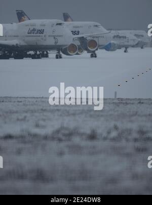 12. Januar 2021, Hessen, Frankfurt/Main: Schnee liegt auf den gestürzte Lufthansa-Passagierflugzeugen, die auf der stillgestellten Nordwest-Landebahn am Frankfurter Flughafen abgestellt sind. Aufgrund der weltweiten Corona-Pandemie und der damit verbundenen Einschränkungen ist der Flugverkehr weiterhin massiv eingeschränkt. Foto: Boris Roessler/dpa Stockfoto