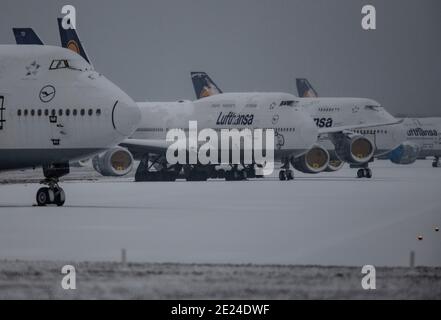 12. Januar 2021, Hessen, Frankfurt/Main: Schnee liegt auf den gestürzte Lufthansa-Passagierflugzeugen, die auf der stillgestellten Nordwest-Landebahn am Frankfurter Flughafen abgestellt sind. Aufgrund der weltweiten Corona-Pandemie und der damit verbundenen Einschränkungen ist der Flugverkehr weiterhin massiv eingeschränkt. Foto: Boris Roessler/dpa Stockfoto