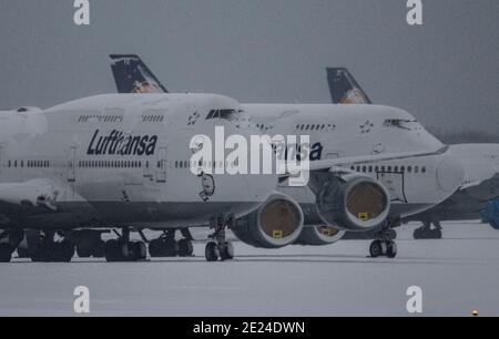 12. Januar 2021, Hessen, Frankfurt/Main: Schnee liegt auf den gestürzte Lufthansa-Passagierflugzeugen, die auf der stillgestellten Nordwest-Landebahn am Frankfurter Flughafen abgestellt sind. Aufgrund der weltweiten Corona-Pandemie und der damit verbundenen Einschränkungen ist der Flugverkehr weiterhin massiv eingeschränkt. Foto: Boris Roessler/dpa Stockfoto