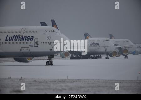 12. Januar 2021, Hessen, Frankfurt/Main: Schnee liegt auf den gestürzte Lufthansa-Passagierflugzeugen, die auf der stillgestellten Nordwest-Landebahn am Frankfurter Flughafen abgestellt sind. Aufgrund der weltweiten Corona-Pandemie und der damit verbundenen Einschränkungen ist der Flugverkehr weiterhin massiv eingeschränkt. Foto: Boris Roessler/dpa Stockfoto