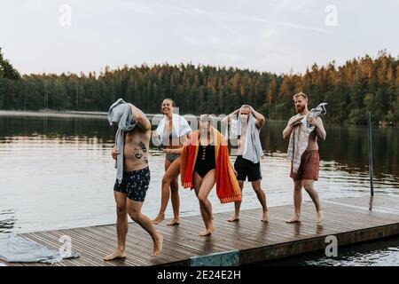 Lächelnde Freunde, die auf dem Steg laufen Stockfoto