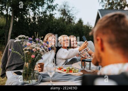 Weibliche Freunde nehmen Selfie im Garten Stockfoto