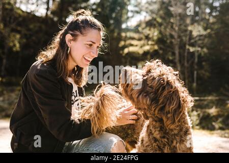 Lächelnde Frau streicheln Hund Stockfoto