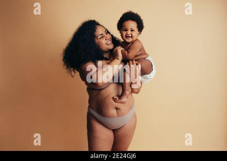 Lächelnd african plus size Frau mit Baby. Gesunde Mutter und Kind. Stockfoto