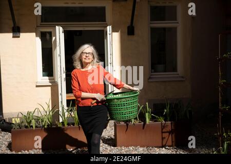 Lächelnde Frau vor Haus Stockfoto
