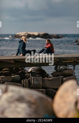 Mutter und Tochter sitzen auf dem Steg Stockfoto