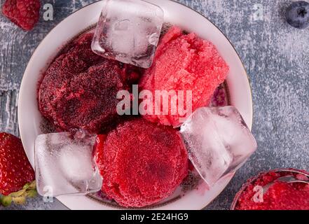 Kugeln aus hausgemachten Erdbeeren, rote Johannisbeere, Himbeere, Heidelbeer-Eis, Sorbet in Schüssel, Sommer-Dessert, süße Snack. Draufsicht Stockfoto