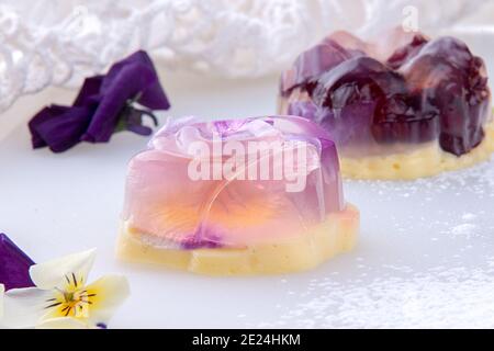 Einzigartigen japanischen Dessert Havaro von Gelee und Bayrisch Creme mit essbaren violetten Blüten. Gelatine gesunde Ernährung Dessert. Stockfoto