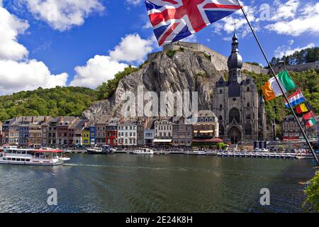 Dinant, eine wunderschöne belgische Stadt, die sich im Fluss mit Flaggen auf der Brücke spiegelt Stockfoto