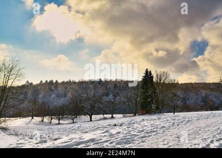 Schneebedeckte Winterlandschaft im deutschen Odenwald mit goldenem Sonnenlicht mit Hintergrundbeleuchtung Stockfoto